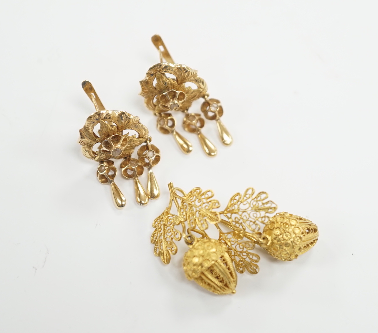 A pair of yellow metal 23mm filigree ‘acorn’ drop earrings and a pair of yellow metal and diamond chip set tassel drop earrings, gross weight 11.1 grams.